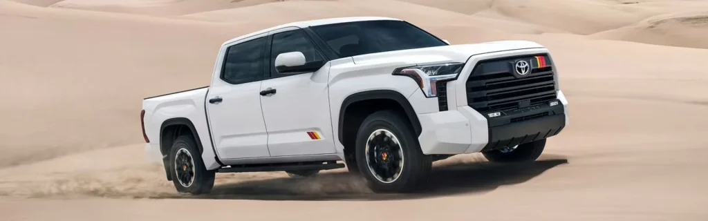 The image shows a white Toyota Tundra TRD Pro pickup truck driving through the desert.