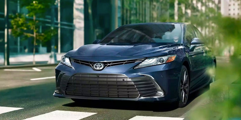 A Toyota Camry drivign through a city