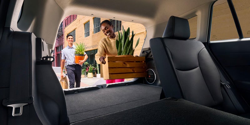 A couple loads plants into the trunk of a Toyota Corolla Cross