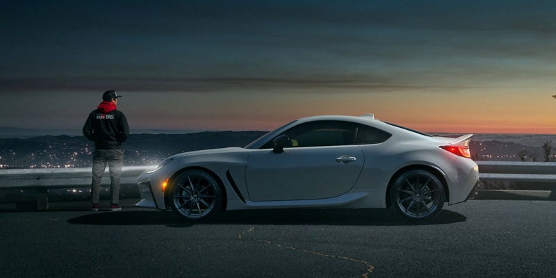 A Toyota GR86 parked on the side of a street at night.