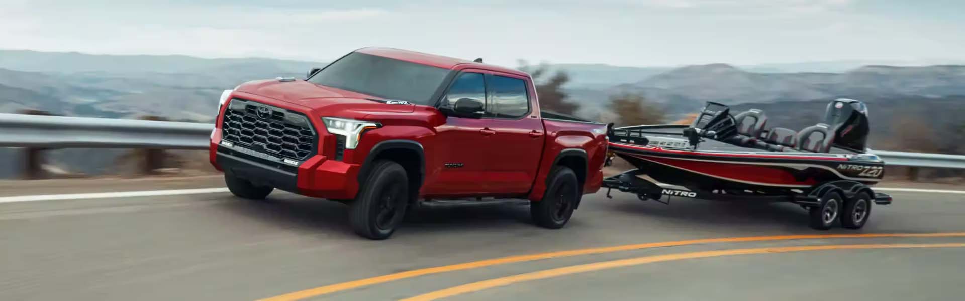 A red Toyota Tundre tows a boat.