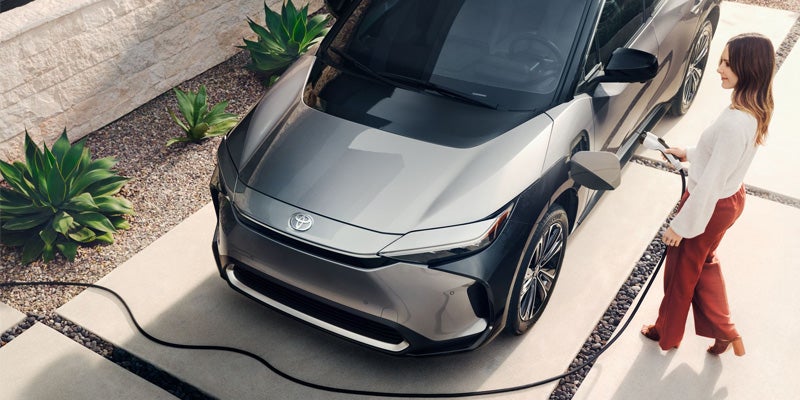 A woman charges her Toyota bZ4X