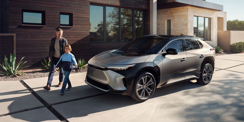 A dad and son walk away from their parked, Toyota bZ4X